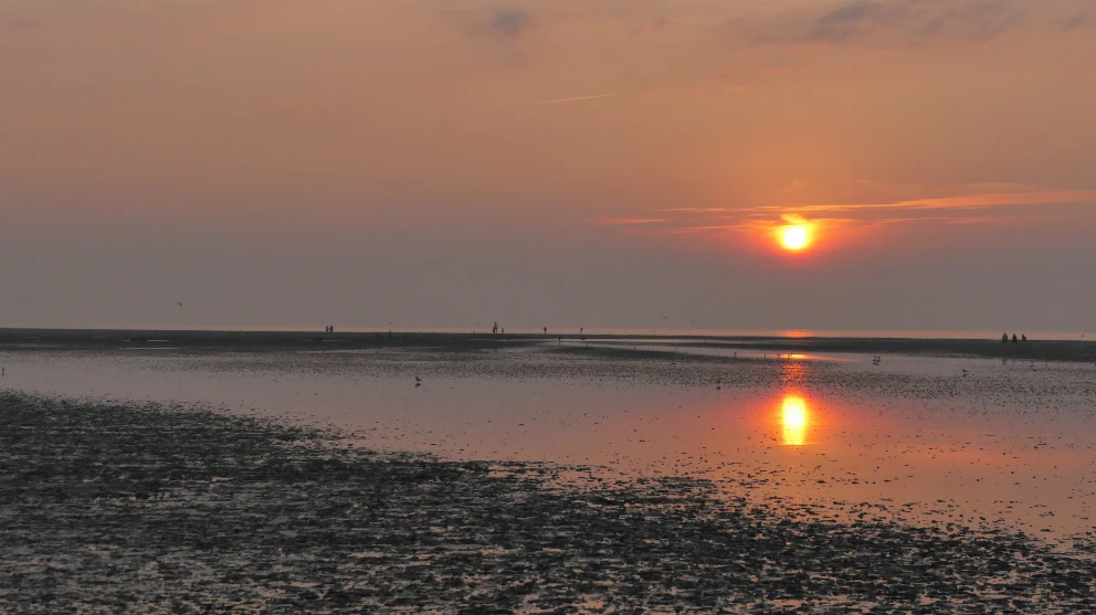 Sonnenuntergang im Nordseeheilbad Duhnen mit Blick auf das Meer bei Watt