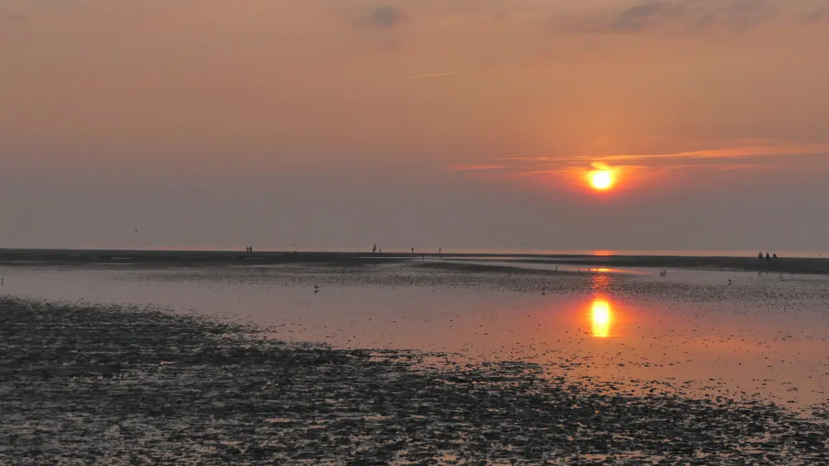 Sonnenuntergang im Nordseeheilbad Duhnen mit Blick auf das Meer bei Watt