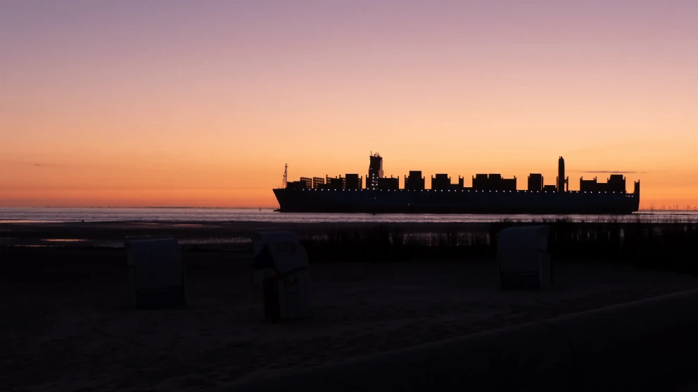 Weltschifffahrtsweg Cuxhaven bei Sonnenaufgang mit Schiff bei der Kugelbake