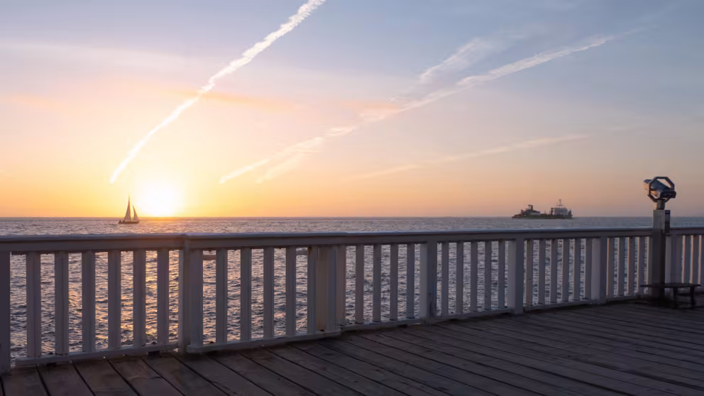 Sonnenaufgang an der Alten Liebe in Cuxhaven mit Blick auf die Elbmündung und Schiffen