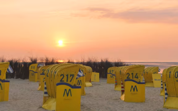 Sonnenuntergang am Strand mit Strandkörben im Urlaub an der Nordsee in Duhnen