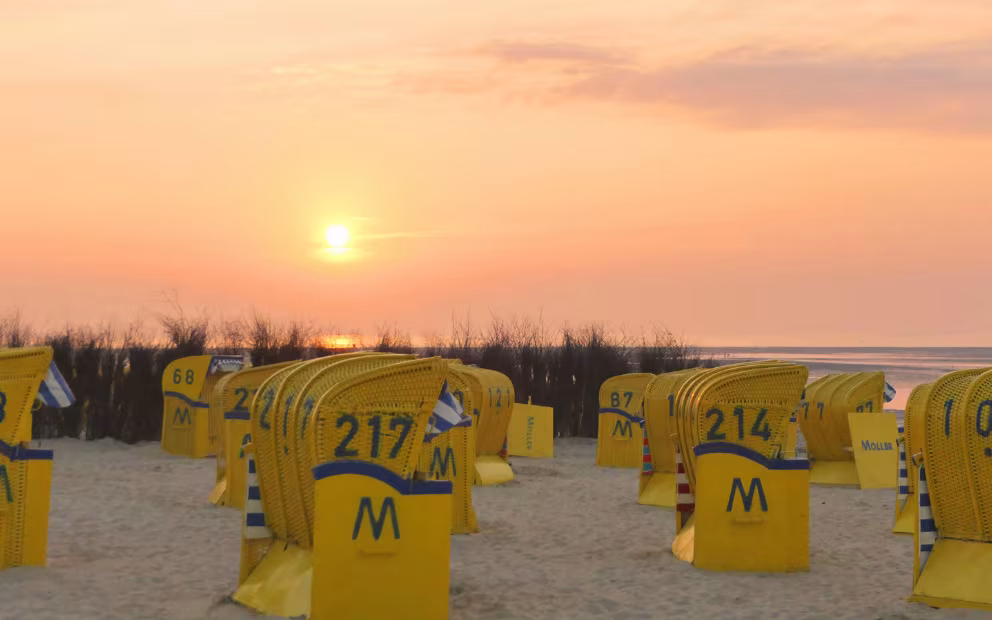 Sonnenuntergang am Strand mit Strandkörben im Urlaub an der Nordsee in Duhnen