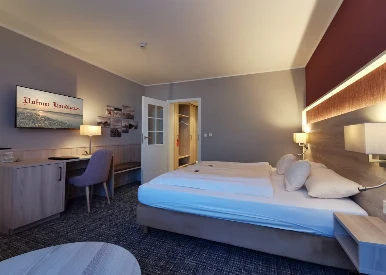 Winterangebot: Blick in ein gemütliches Hotelzimmer mit warmen Farben im Duhner Landhaus