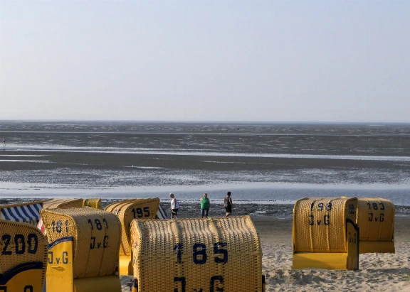 Blick vom Strand auf das Wattenmeer und Strandkörbe